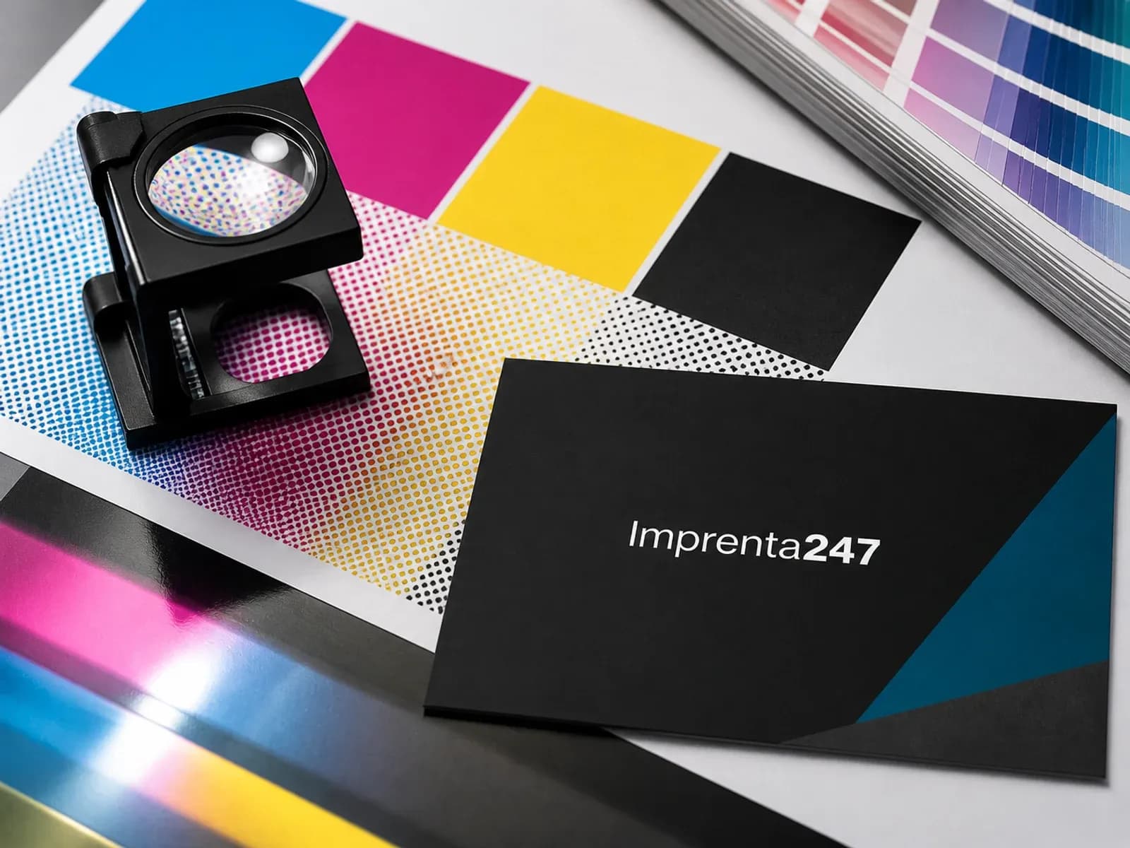 Prueba de color CMYK, lupa de trama y tarjeta impresa con el logotipo Imprenta247